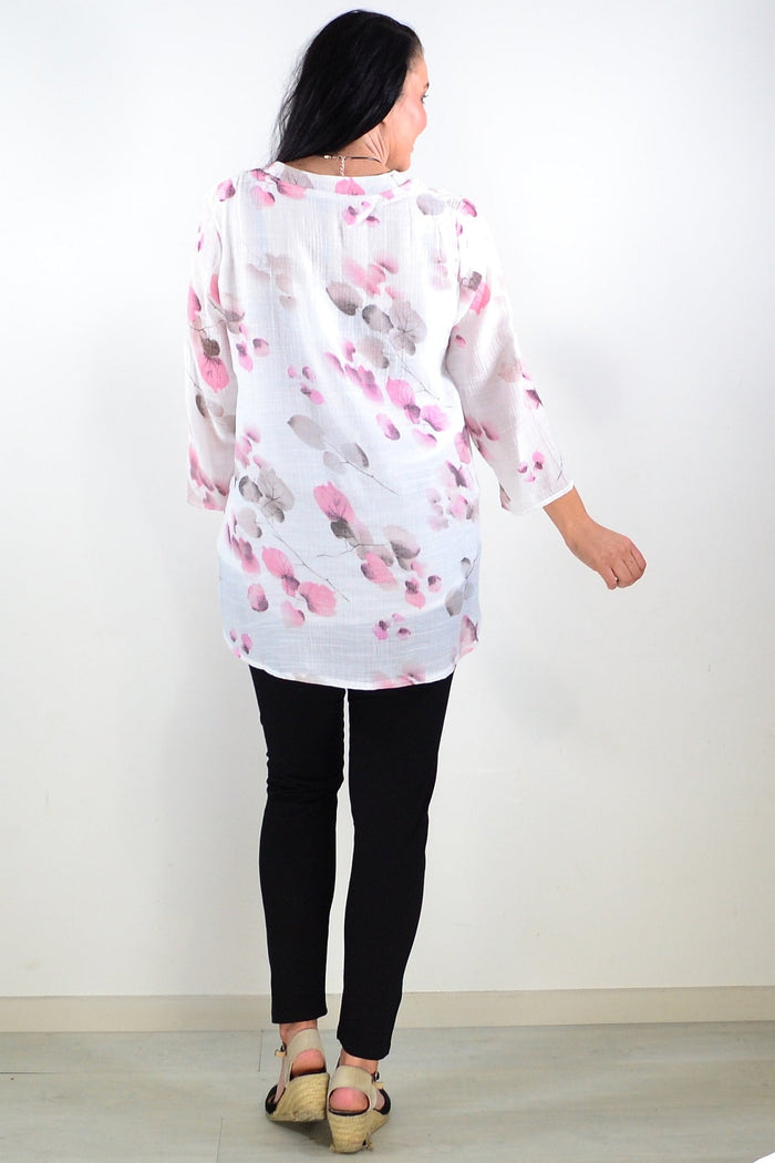 Pink floral botanical tunic top by Caroline Morgan, featuring a flowy silhouette and vibrant flower print, shown on a hanger.