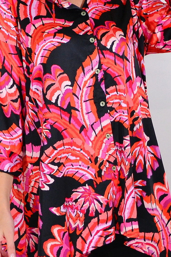 Pink orange satin tunic shirt by Caroline Morgan, showcasing smooth fabric and relaxed fit on a model.