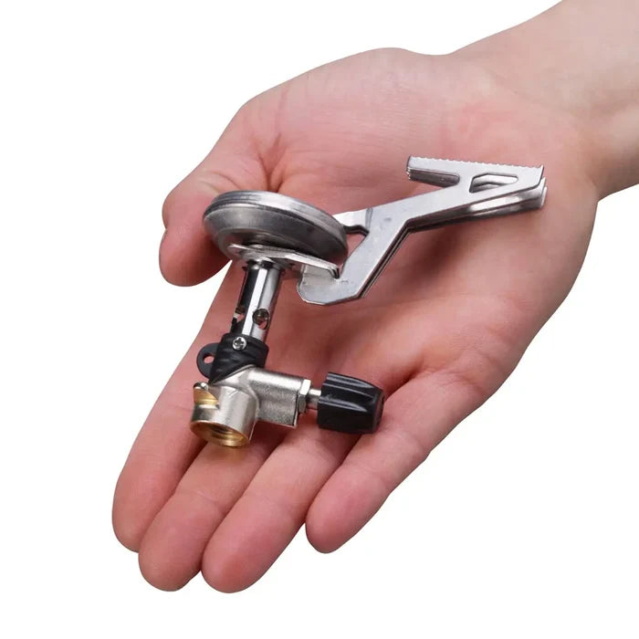 A Collapsed Primus Express camping gas stove held in the palm of someones hand to show the relative size