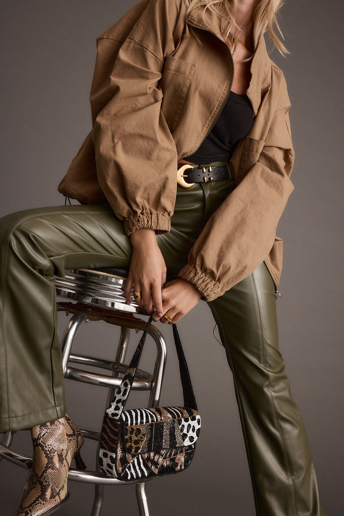 Close-up of the Ryland Olive Vegan Leather Flare Pants showcasing the vegan leather texture and craftsmanship.