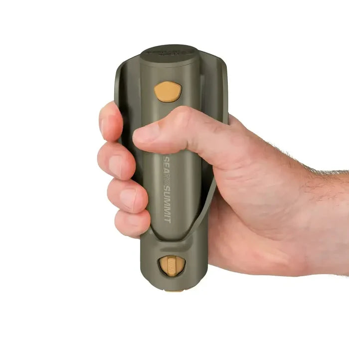 Hand holding a Sea To Summit Nylon Pocket Trowel folded up on a white background