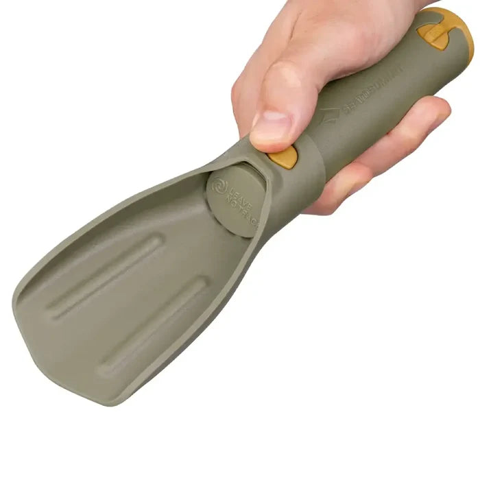 Hand holding a Sea To Summit Nylon Pocket Trowel on a white background