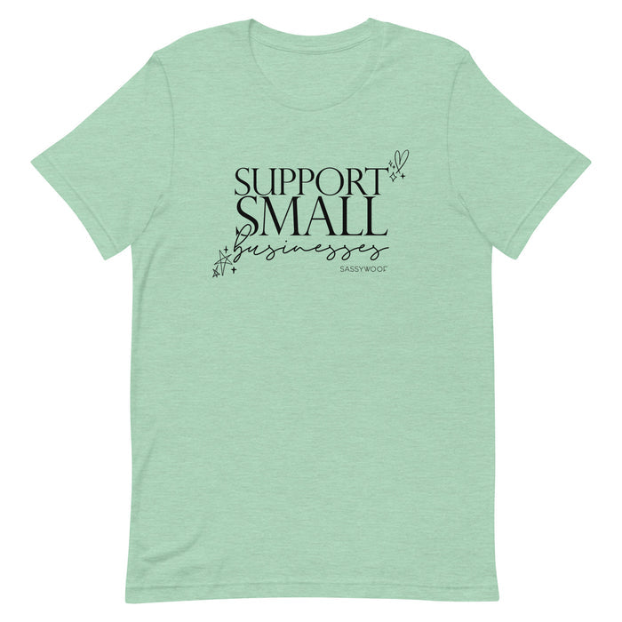 The Sassy Woof Support Small Businesses Tee is a light green unisex shirt with “Support Small Businesses” in black decorative text, plus star, heart, and swirl accents—a comfy way to show your support.