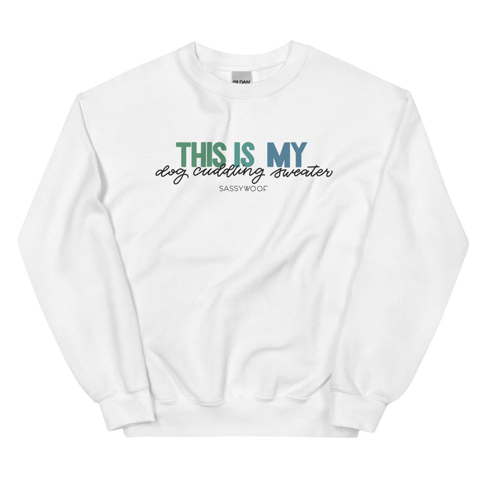 The Sweatshirt - This is My Dog Cuddling Sweater by Sassy Woof features "THIS IS MY dog cuddling sweater" in blue, green, and black, plus Sassy Woof branding. This cozy unisex crewneck is perfect for snuggling with your pup.