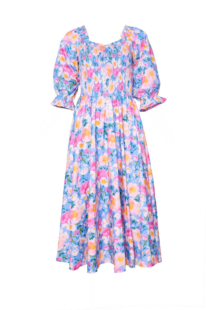 The Ivy City Co Teagan Dress in Delia Blue is a maternity-friendly floral midi with puffed short sleeves, smocked bodice, and flowy skirt. Pink, yellow, and blue blooms on light blue give it an effortlessly pretty look.
