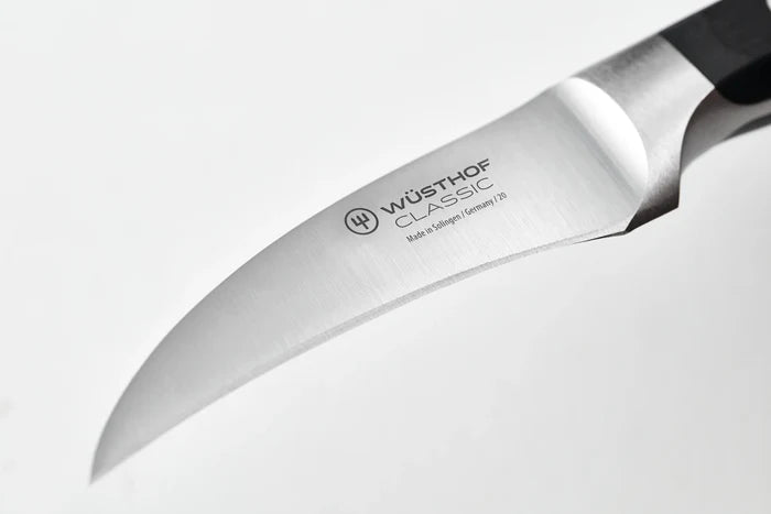 A Wusthof Classic peeling knife with a 2.8-inch carbon steel blade and black plastic handle with red accents. Blade shows "Wusthof Classic, Made in Solingen / Germany / 20."
